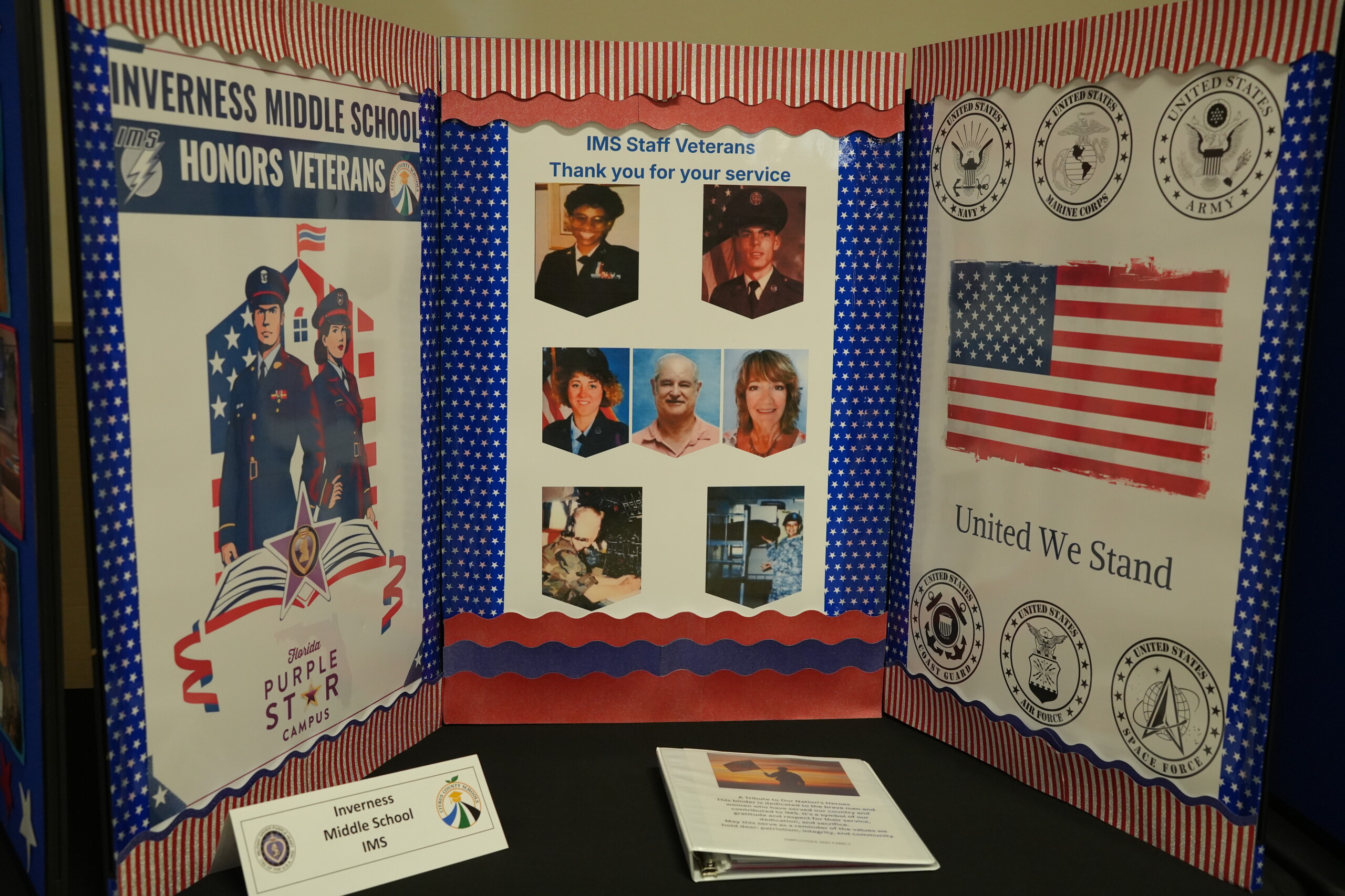 A trifold display titled 'Inverness Middle School Honors Veterans' features staff veteran photos and patriotic decorations.